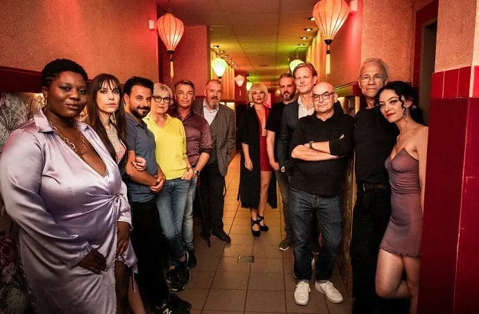 Group photo of the cast of Tatort Köln – Siebte Etage in a hallway with red lanterns
