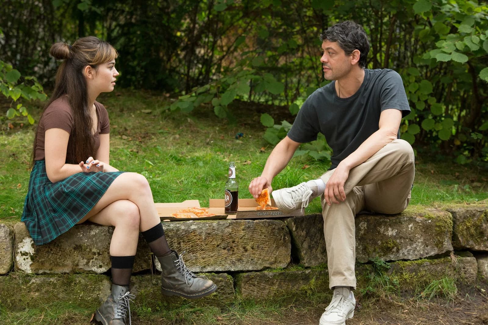 Scene from the series Safe: a girl and a man sitting on a stone wall outdoors